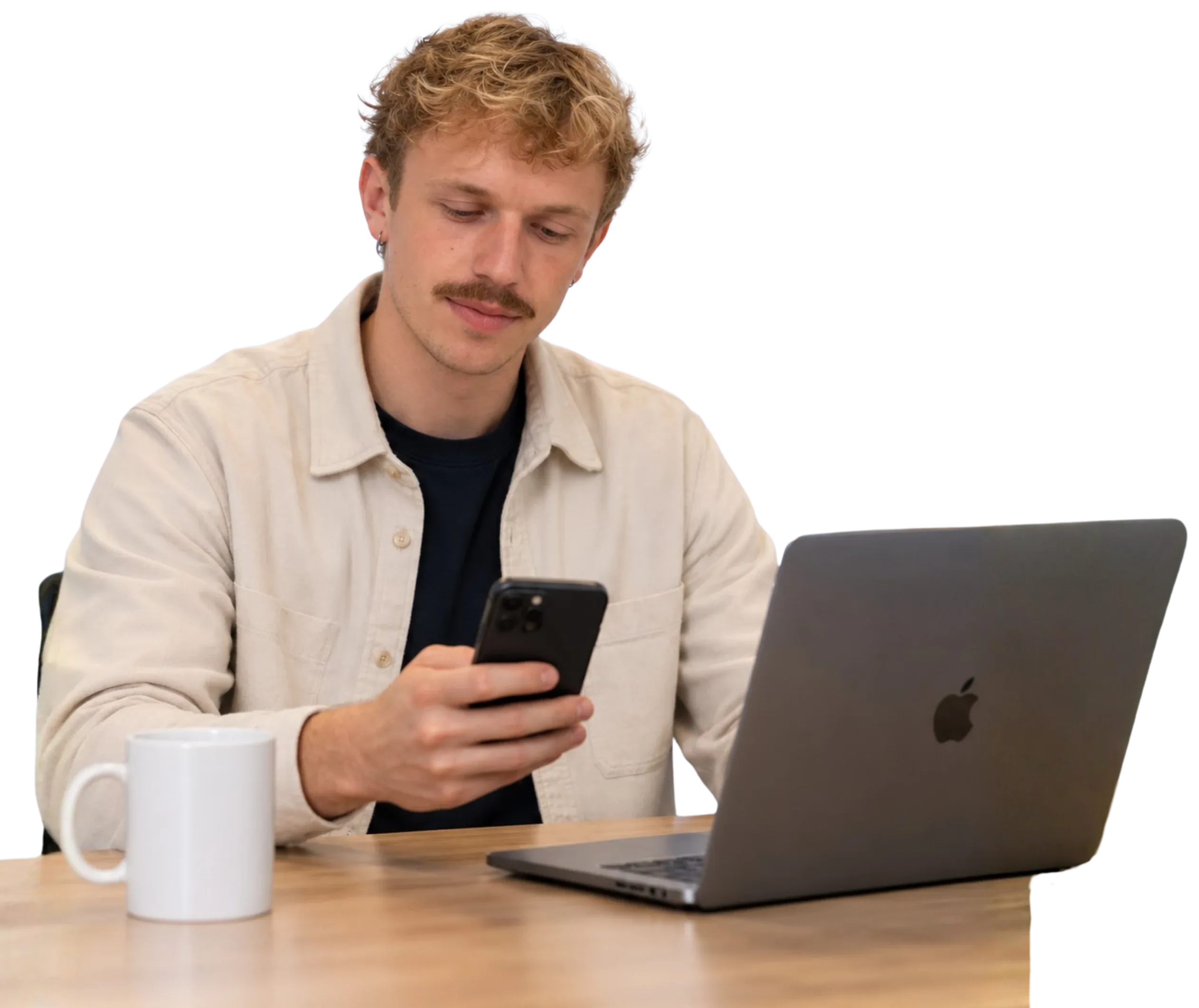 Timo, co-founder of Traffic To Talks, at a table with his phone and an open laptop
